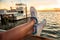 Woman legs over the sea bay and yachts at sunset time