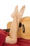 Woman legs with red sheet knees down crossed with guitar