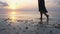 Woman legs on sandy beach. Girl walking on sand by the sea during sunset. Beach travel. Summer vacations concepts