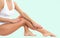 Woman legs with smooth skin after depilation on pastel green background.