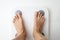 Woman legs stepping on floor scales, close-up