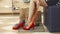 Woman legs trying red shoes on close up