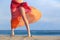 Woman legs on vacations posing on the beach with a pareo