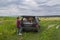 Woman lets dogs out of car in field for a walk