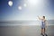 Woman Letting Go Of Balloons On Beach