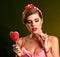 Woman lick lollipops. Girl in pin-up style hold striped candy.