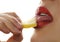 Woman licks and eating juicy lemon, close-up lips on a white background.