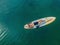 A woman lies on a sup, view from a drone. Young women Having Fun Stand Up Paddling in the sea. SUP. Red hair girl