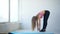 Woman lifting down her torso and doing stretching. Scene in the fitness studio.