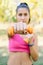 Woman lifting orange weights in the park