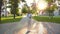 Woman in light suit goes to work with tablet in hand. Beautiful female businesswoman walks along alley in park and