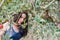 Woman in a light summer dress framed by twigs of apple trees in