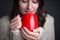 Woman in a light sweater holding a red cup of coffee