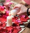 woman lighting a candle over rose petal background. stones, herbs and candles during spiritual practice. magical rituals
