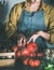 Woman in linen apron taking tomatoes out of basket