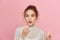 Woman with lip gloss. Photo of woman with perfect makeup on pinkbackground. Beauty concept