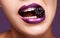 Woman lips, purple lipstick with blackberry and makeup, shine and creativity with beauty isolated on studio background