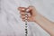 Woman lit hand counts mala beads strands of gemstones used for keeping count during mantra meditations. Marble light