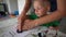 Woman with little boy making palm hand print stamp with gouache paint