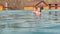 Woman and the little girl swims in the outdoor pool