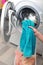 Woman loading clothes in washing machine