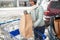 Woman loading food from shopping cart to car trunk