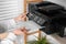 Woman loading paper into printer on shelf indoors, closeup