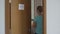 A woman locked down in a self-quarantine stands in front of the door with a bag full of fresh vegetables and fruits