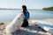 Woman with Locs Sitting on the Beach of City Lake with Her Best Friend, Dog Breed Japanese Spitz, and Preparing for