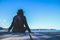 A woman lonely sitting on the wooden pier at the sea with blue sky.