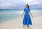 Woman in a long blue dress goes on the sea coast Cayo Largo island, Cuba