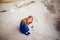 Woman with long carrot hair is crouching and hugging herself in