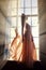 Woman in long dress stands at window in sunlight. Fairy Princess