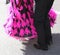 Woman with long fuchsia dress dancing with a man on the street