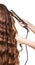 Woman with long hair and hand barber curler isolated.