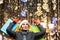 A woman with long hair and a Santa hat near the window of a city store with purchases in colorful, paper bags. New year`s shoppin