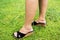 Woman with long hairy leg standing on grass floor