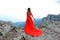 Woman in long red dress on the edge of a cliff in the mountains. Peak of Ai-Petri mountain