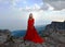 Woman in long red dress on the edge of a cliff in the mountains. Peak of Ai-Petri mountain