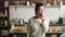 Woman looking between apple and eclair. Brunette girl eating tasty cake at home.