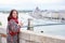 Woman looking back at camera against view Hungarian Parliament