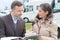 Woman looking at brochure with vehicle salesman