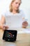 Woman Looking At Domestic Bills With Smart Energy Meter In Foreground