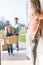 Woman looking at family with cardboard boxes entering new home