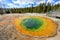 Woman looking at the famous Morning Glory Pool in Yellowstone National Park, USA