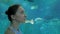 Woman looking at fish vortex in large public aquarium tank at Oceanarium