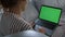 Woman looking green screen laptop at remote workplace closeup. Girl browsing web