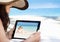 Woman looking at her picture on digital tablet at beach