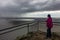 A woman looking at incoming storm on Reeds Lookout in Grampians National Park, Victoria, Australia.