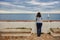Woman looking at infinite sea and sailboat